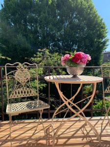 a table with a vase of flowers and two chairs at Korfuvej.rent.a.room in Copenhagen