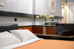 Schlafzimmer mit einem Bett und einem TV auf einem Schreibtisch in der Unterkunft Victory Inn in Athen