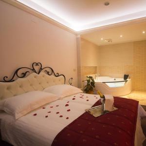 ein Schlafzimmer mit einem Bett mit roten Rosenblättern drauf in der Unterkunft Guest House Šterk in Nova Gorica