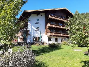 a hotel in the middle of a park with trees at Hotel Aquamarin in Bad Mitterndorf