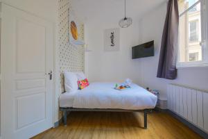 a white room with a bed and a door at Apartments WS Haussmann - La Fayette in Paris
