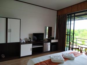 1 dormitorio con cama, TV y balcón en Phumok Village Khao Kho en Khao Kho