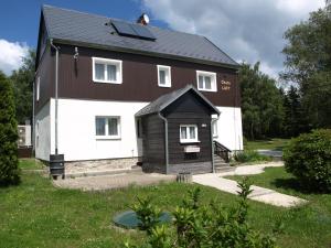 een groot bruin en wit huis met een zwart dak bij Guest House LUFT Sněžník in Sněžnik