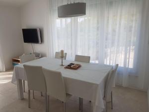 a white dining room with a white table and chairs at Vila Hrvatska in Ražanj
