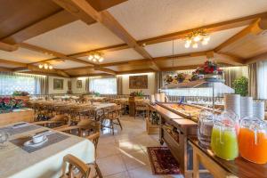 a restaurant with tables and chairs and orange juice at Hotel Pension Rechtenthal in Termeno