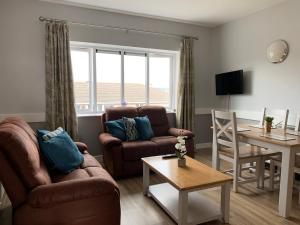 a living room with a couch and a table and a dining room at Priory House, Student Accommodation, Manor Village apartments, Cork Road, X91W427 in Waterford