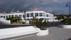 ein weißes Gebäude mit Bäumen davor in der Unterkunft Abades Chalet in La Listada