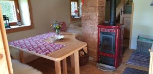 Habitación con mesa y estufa de leña. en MOUNTAIN ECO CHALET KONJSKA DOLINA on 1400 m asl -near Pokljuka, en Srednja Vas v Bohinju