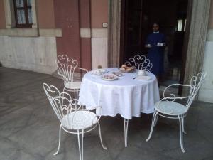 a white table with chairs and a person standing in a building at Casa S. Giuseppe di Cluny in Rome