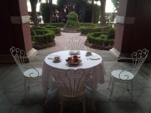 un tavolo e sedie in un giardino con cespugli di Casa S. Giuseppe di Cluny a Roma