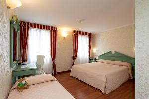 Ένα ή περισσότερα κρεβάτια σε δωμάτιο στο Hotel Tintoretto