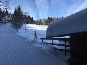 a snow covered building with a picnic table in the snow at Haus an der Bergwiese in Waldkirchen +3 photos
