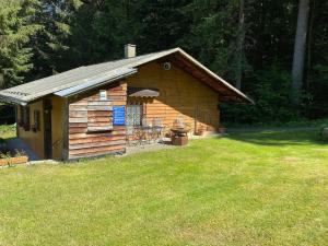 a log cabin with a grill in a yard at Haus an der Bergwiese in Waldkirchen