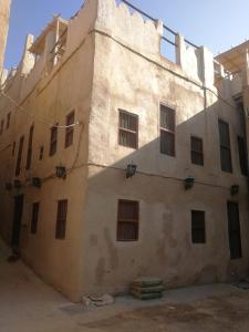 un edificio antiguo con muchas ventanas en Al Hamra Old House, en Al Ḩamrāʼ