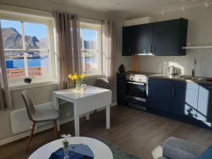 a kitchen with a table and a kitchen with a view at Bensvik Brygge in Værøy