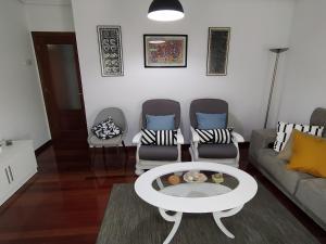 sala de estar con sofá, 2 sillas y mesa en Duplex de 130m2 al lado de las playas de Cuchia, en Miengo