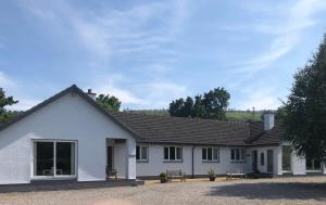 a white house with benches in front of it at Aslaich in Drumnadrochit