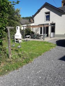 a house with a fence and a statue in the yard at Label Semois Gite rural 3 épis in Bouillon
