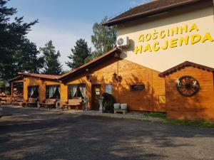 un edificio de madera con un oso fuera de él en Gościnna Hacjenda, en Radwanice