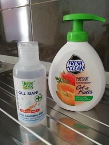una botella de limpiador fresco junto a un recipiente de aderezo fresco para ensaladas en Blau Vacanze, en Peschiera del Garda