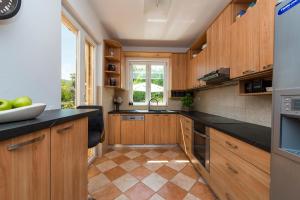 a kitchen with wooden cabinets and black counter tops at Apartment Green Gold in Dubrovnik