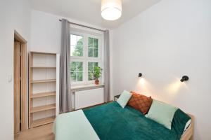 a bedroom with a bed and a window at YOURAPART Ogarna in Gdańsk