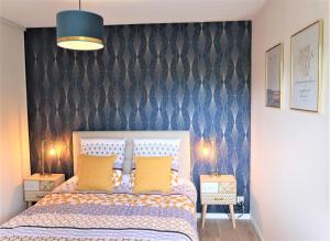 a bedroom with a bed and a blue wall at Appart'Confort - Le Trégor in Lannion