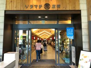 a store entrance with people walking into a store at COTO Tokyo Asakusa 5 in Tokyo