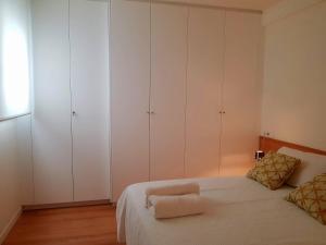 a bedroom with white cabinets and a white bed at Vivienda Bendicho- CATEDRAL in Almería