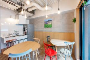 a kitchen with two tables and chairs in a room at plat hostel keikyu asakusa station in Tokyo