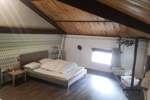 a bedroom with a bed in a room with a window at Le moulin de chante oiseau in Borne