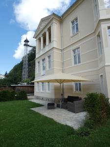 un grand bâtiment avec un parasol devant lui dans l'établissement Villa Norma, à Bad Schandau