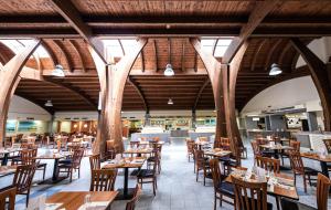 um restaurante vazio com mesas e cadeiras de madeira em Blu Salento Village em Sant'Isidoro