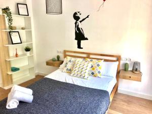 a bedroom with a bed with a woman flying a kite at Apartamento Centrico - Casta Alvarez in Zaragoza