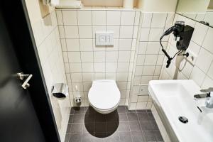 a bathroom with a toilet and a sink at McDreams Hotel München - Messe in Feldkirchen