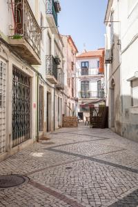 an empty street in an alley with buildings at Ana´s House in Setúbal