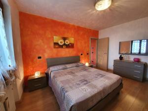 ブレンゾーネにあるCasa Valentiのオレンジ色の壁のベッドルーム1室(大型ベッド1台付)
