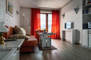 a living room with red curtains and a couch and a table at Ferienwohnung Sabolowitsch in Lam