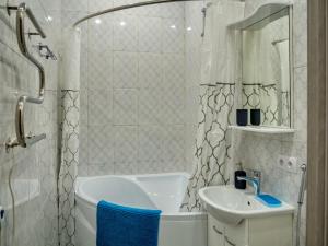 y baño con bañera, lavamanos y ducha. en La Casa Di Bury Apartments 2, en San Petersburgo