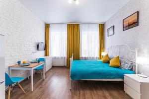 a bedroom with a bed and a table and a desk at La Casa Di Bury Apartments 2 in Saint Petersburg