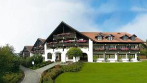 un gran edificio con un césped verde delante de él en Appartementhotel Griesbacher Hof, en Bad Griesbach