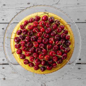 a cake with cherries on top on a glass plate at Casale Sterpeti in Magliano in Toscana