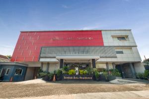 a large building with a red and white facade at OYO Flagship 3726 Tembok Batu Residence in Yogyakarta