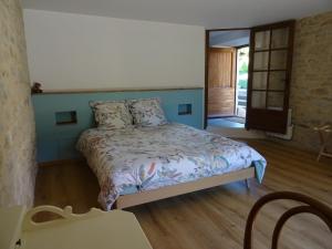 a bedroom with a bed and a wooden floor at La Terralha in Saint-Pierre-Toirac
