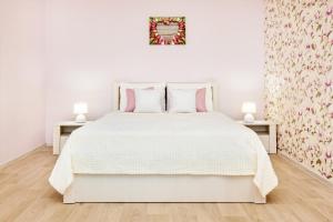 トリヤッチにあるPink Panther Apartment SUTKI LIFEの白いベッドルーム(ピンクの枕が付いた白いベッド付)