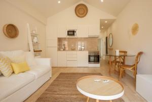 ein Wohnzimmer mit einem weißen Sofa und einem Tisch in der Unterkunft Ana´s House in Setúbal