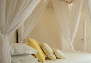 sypialnia z białymi zasłonami i łóżkiem z poduszkami w obiekcie Ana´s House w mieście Setúbal