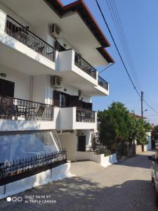 un edificio blanco con balcones en un lateral en Elsa Apartments, en Pefkohori