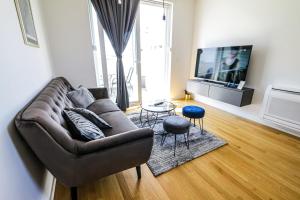 a living room with a couch and a tv at Luce Gold Apartment in Zadar