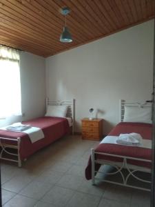 a bedroom with two beds and a wooden ceiling at Grivas House in Vourvourou